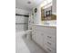 Bathroom with marble floors and shower-tub, featuring a single sink vanity at 30 Turner St # 202, Clearwater, FL 33756