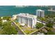 Wide aerial shot of a condominium complex with lush landscaping, pool, parking, and ocean views at 30 Turner St # 202, Clearwater, FL 33756