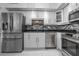 Bright kitchen features stainless steel appliances, white cabinets, and mosaic backsplash at 30 Turner St # 202, Clearwater, FL 33756