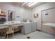 Well-lit laundry room with washer, dryer, sink, mirror, and trash door at 30 Turner St # 202, Clearwater, FL 33756