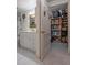 Hallway view into a bathroom and an adjacent pantry with shelves stocked at 30 Turner St # 202, Clearwater, FL 33756