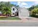 Charming two-story home with a well-manicured lawn, palm tree, and a basketball hoop over the garage at 3221 W Oakellar Ave, Tampa, FL 33611