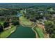 Scenic aerial view of the golf course featuring lush greenery, water features and tree-lined fairways at 3585 Torino Ln, Palm Harbor, FL 34683