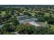 Overhead shot showcasing the property's multiple tennis courts, greenery, and proximity to neighborhood at 3585 Torino Ln, Palm Harbor, FL 34683