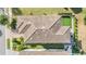 Bird's eye view of a luxury home displaying its unique roof design and surrounding greenery at 3585 Torino Ln, Palm Harbor, FL 34683