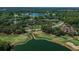 Overhead view of a golf course surrounded by trees and lake at 3585 Torino Ln, Palm Harbor, FL 34683