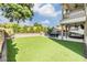 Backyard featuring an outdoor kitchen, dining area, and manicured lawn at 3585 Torino Ln, Palm Harbor, FL 34683
