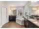 Bathroom featuring granite counters, dual sinks, tub, and natural light at 3585 Torino Ln, Palm Harbor, FL 34683