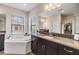 Primary bathroom featuring granite counters, dual sinks, tub, and neutral colors at 3585 Torino Ln, Palm Harbor, FL 34683