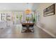 Open dining room with tile floors, modern light fixture, and access to outdoor balcony at 3585 Torino Ln, Palm Harbor, FL 34683