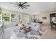 Bright, open living room with large windows, a ceiling fan, and comfortable seating at 3585 Torino Ln, Palm Harbor, FL 34683