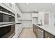 Modern kitchen featuring white cabinets, stainless steel appliances, and a quartz countertop island at 37202 Clinch Cir, Zephyrhills, FL 33540