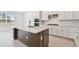 Well-lit kitchen features modern appliances, white cabinets and a gray center island with quartz countertops at 37202 Clinch Cir, Zephyrhills, FL 33540