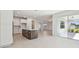 Open-concept kitchen with center island, white cabinets, and stainless appliances with easy access to backyard at 37202 Clinch Cir, Zephyrhills, FL 33540