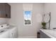 Well-lit laundry room features modern cabinetry, sleek sink, and convenient washer and dryer at 37202 Clinch Cir, Zephyrhills, FL 33540
