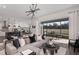 Open-concept living room with a large sectional sofa, modern lighting, and a view of the outdoor patio at 37202 Clinch Cir, Zephyrhills, FL 33540