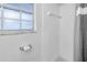 Bright bathroom featuring white tiled walls and shower with a window for natural light at 3753 Hollow Oak Pl, Land O Lakes, FL 34639