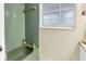 A full bathroom with a green tub and shower, and a bright window at 3753 Hollow Oak Pl, Land O Lakes, FL 34639
