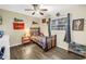 A decorated bedroom with bed, wood floors, a ceiling fan, and natural light at 3753 Hollow Oak Pl, Land O Lakes, FL 34639