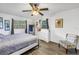 A cozy bedroom with wood floors, a ceiling fan, and great natural light at 3753 Hollow Oak Pl, Land O Lakes, FL 34639