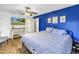 Bedroom with hardwood floors, bold blue accent wall, and flat screen tv at 3753 Hollow Oak Pl, Land O Lakes, FL 34639