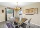 Bright dining room with a wooden table, white chairs, natural light, and decorative wall art at 3753 Hollow Oak Pl, Land O Lakes, FL 34639
