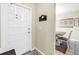 Bright entryway featuring a white front door, decorative welcome sign, and a glimpse of a cozy dining area at 3753 Hollow Oak Pl, Land O Lakes, FL 34639