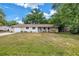 Charming single-story home with a covered porch and a swing, set in a lush, green front yard under a sunny sky at 3753 Hollow Oak Pl, Land O Lakes, FL 34639