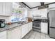 Bright kitchen featuring white cabinetry, granite countertops, and stainless steel appliances with a tile floor at 3753 Hollow Oak Pl, Land O Lakes, FL 34639
