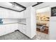 Bright kitchen with white cabinets and drawers leading to a dining area with barn-style art at 3753 Hollow Oak Pl, Land O Lakes, FL 34639