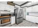 Bright kitchen featuring white cabinetry, stainless steel appliances, and tile flooring at 3753 Hollow Oak Pl, Land O Lakes, FL 34639