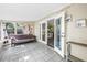 Bright sunroom with white tile flooring, futon sofa, and view to the backyard at 3753 Hollow Oak Pl, Land O Lakes, FL 34639