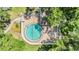 Aerial view of a circular swimming pool with brick patio, surrounded by mature landscaping at 4002 Cypress Ct # 4002, Tampa, FL 33618