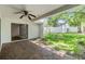 Covered brick patio featuring a ceiling fan and sliding glass doors opening to a lush green backyard at 4002 Cypress Ct # 4002, Tampa, FL 33618
