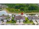 An aerial view features a house surrounded by lush landscaping and a peaceful pond, perfect for families at 4220 Barletta Ct, Wesley Chapel, FL 33543