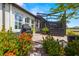 Backyard patio and enclosing screened-in porch, surrounded by well-kept gardens at 4220 Barletta Ct, Wesley Chapel, FL 33543