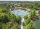 Aerial shot of a community basketball court nestled among trees, showcasing green and blue surfaces with nearby walking path at 4220 Barletta Ct, Wesley Chapel, FL 33543