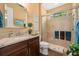 Well-lit bathroom featuring granite countertop, wood cabinets, and a tiled walk-in shower at 4220 Barletta Ct, Wesley Chapel, FL 33543