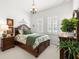 Charming bedroom features a wooden bed frame, plantation shutters, and serene decor at 4220 Barletta Ct, Wesley Chapel, FL 33543