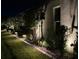 Home exterior at night showcasing garden bed with landscape lighting along the manicured lawn at 4220 Barletta Ct, Wesley Chapel, FL 33543