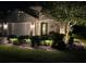 Charming home at night with manicured front yard featuring professional landscape lighting and stone accents at 4220 Barletta Ct, Wesley Chapel, FL 33543
