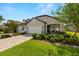 Charming single-story home with stone accents, a three-car garage, manicured lawn, and inviting front porch at 4220 Barletta Ct, Wesley Chapel, FL 33543