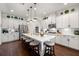 Bright kitchen featuring white cabinets, stainless steel appliances, a large island with seating, and modern pendant lighting at 4220 Barletta Ct, Wesley Chapel, FL 33543