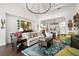 Bright living room with a large chandelier, comfortable seating, and open access to the modern kitchen at 4220 Barletta Ct, Wesley Chapel, FL 33543