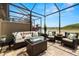 Covered patio featuring a cozy seating area and relaxing views of the lake at 4220 Barletta Ct, Wesley Chapel, FL 33543