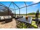 Enclosed patio area with stylish seating, dining table, and tranquil waterfront vista at 4220 Barletta Ct, Wesley Chapel, FL 33543
