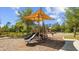 A community playground featuring a variety of play equipment, shade structures, and a soft ground cover under a sunny sky at 4220 Barletta Ct, Wesley Chapel, FL 33543