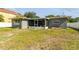 A lush backyard view showcasing a home with an enclosed patio, creating a relaxing outdoor space at 4610 W Mcelroy Ave, Tampa, FL 33611