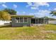 Backyard showcasing the home's exterior and screened patio, offering a seamless transition to outdoor living at 4610 W Mcelroy Ave, Tampa, FL 33611