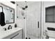 Modern bathroom features a glass-enclosed shower with black fixtures and marble-look tile at 4610 W Mcelroy Ave, Tampa, FL 33611